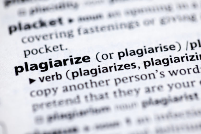 Plagiarism definition, close up view dictionary