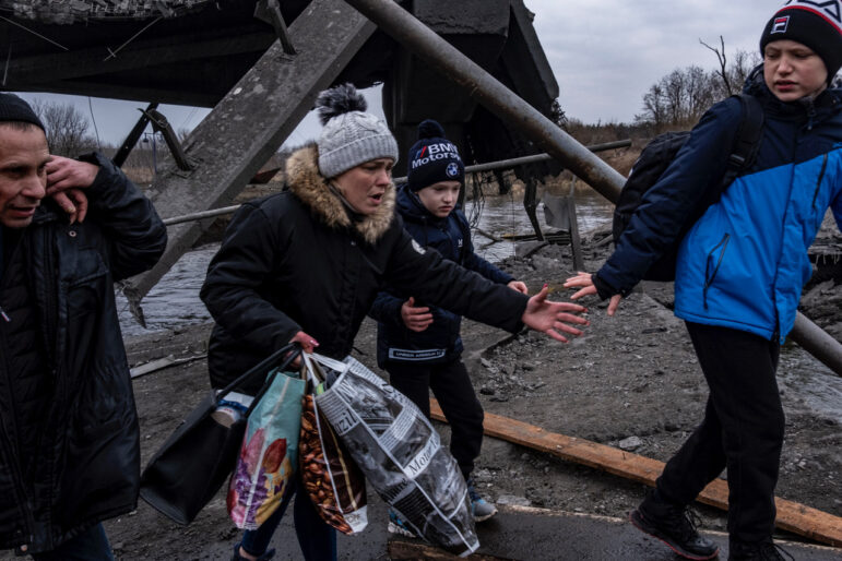 People flee Russian forces advance in the town of Irpin March 7, 2022.They were forced to cross a bridge, destroyed by Ukrainians and pass through areas that have been attacked by artillery.