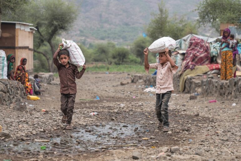 Children in the Houthi-controlled Yemeni city of Taiz carry bags of food, Image: Shutterstock