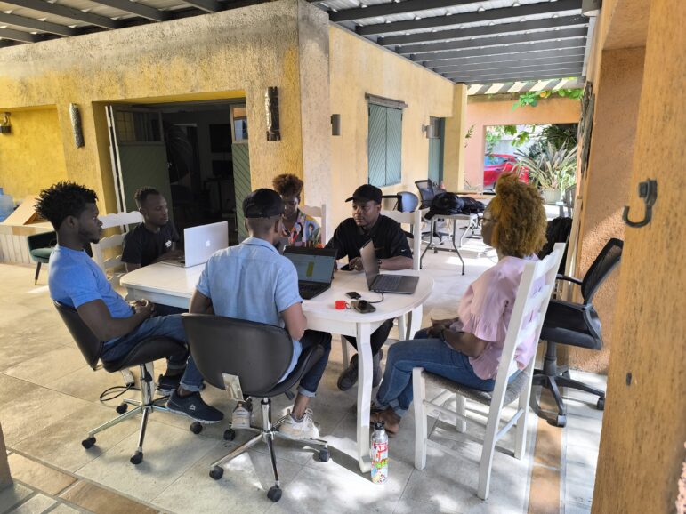 "The team of the AyiboPost discuss the stories they are working on at their current newsroom in the Haitian capital, Port-au-Prince. Image: Courtesy of the team