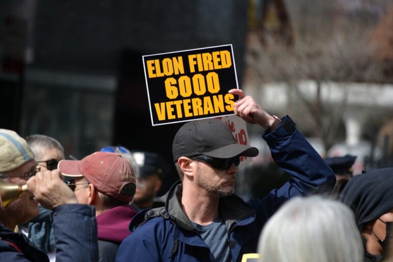 Demonstrators at a March 2025 event protesting cancelled contracts and thousands of job cuts at the Department of Veterans Affairs by the Elon Musk-led ad-hoc Trump White House group DOGE.