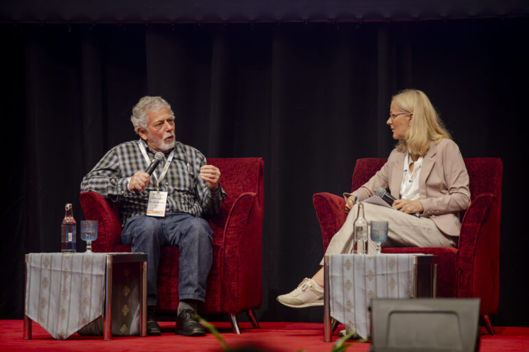 Gustavo Gorriti, left, speaks with Finnish investigative reporter Minna Knus-Galán in one of the keynote speeches of GIJC25. Image: Alt Studio for GIJN