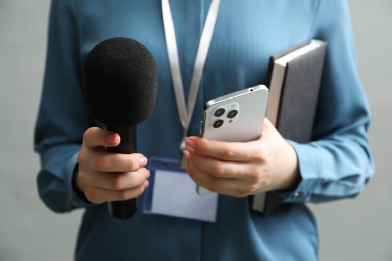 women investigative journalist holding microphone