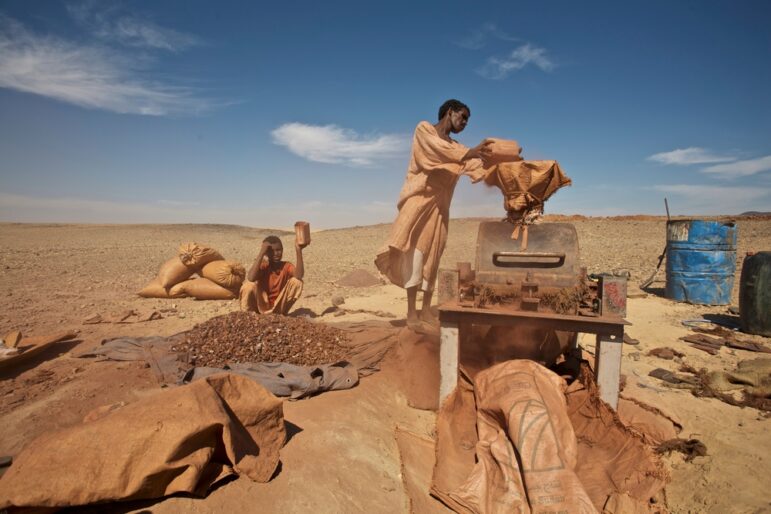 Working in a small gold mine in the Sudanese desert. Crushing gold-bearing ore before panning the gold ore. Sudan.