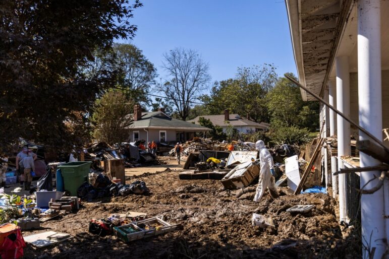 People,Drive,Past,Piles,Of,Debris,Lining,The,Road,After