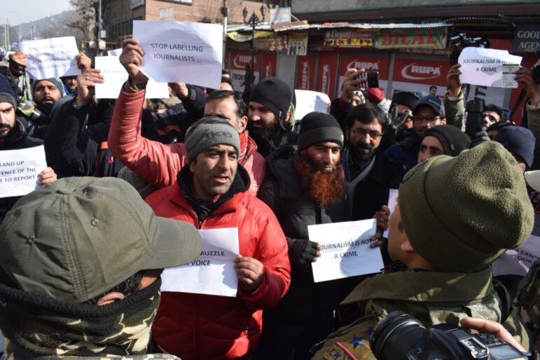 Indian policemen stop Kashmiri journalists from proceeding ahead during a protest in Srinagar.