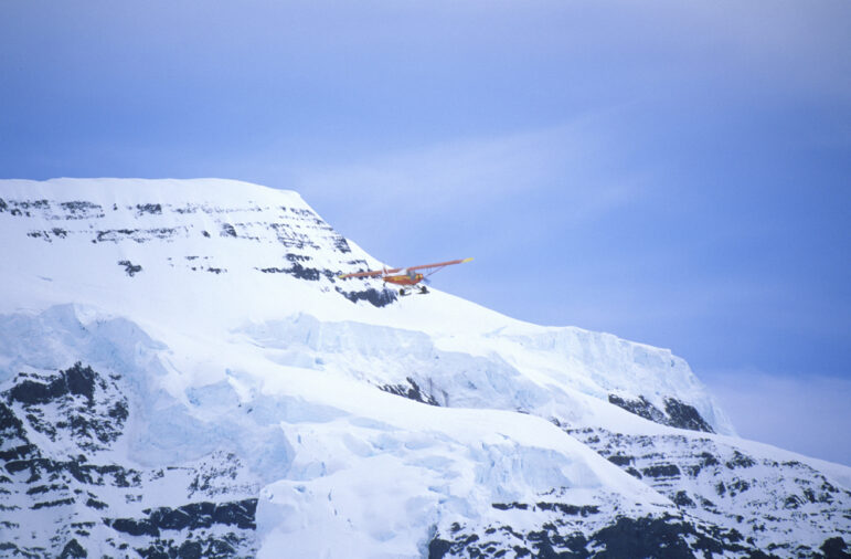 A bush plane flying over the Wrangell Mountains in St. Elias National Park & Preserve in Alaska.